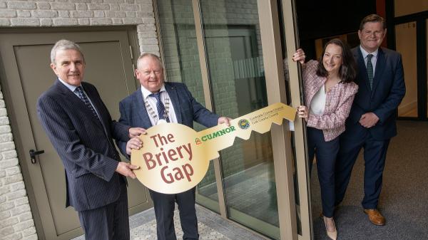 Three men and one woman pictured with 2 of the men holding an oversized cardboard key on which is written Briery Gap, Cumnor Construction and Cork County Council.