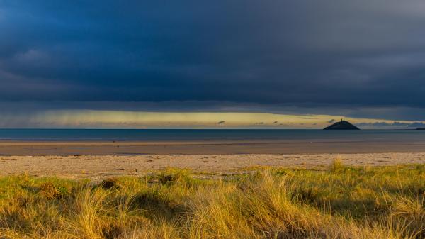 Sandy Beach on a Dark Cloudy Day with an Distant Island on the Left