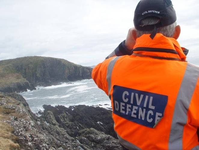 Civil Defence guard using binoculars.