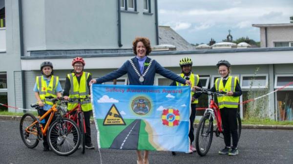 The Mayor of the count of Cork, Councillor Gillian Coughlan holding a banner for cycling safety with children of a local school