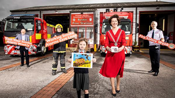 Mayor with Fire Service staff and schoolchild with painting of smoke alarm