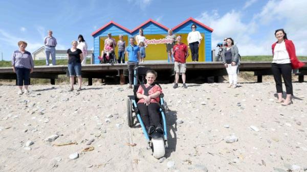 Photocall at Redbarn, representatives from all stakeholders and wheelchair users with one in beach wheelchair