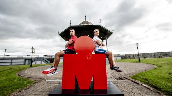 A woman and a man sitting on the letter M