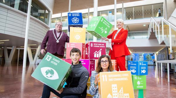 A group of people holding coloured boxes