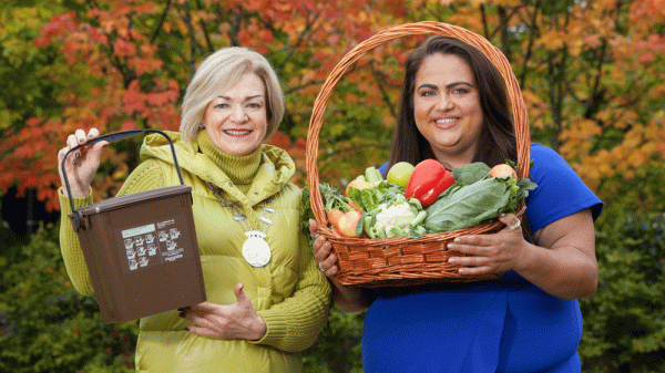 Two women holding props