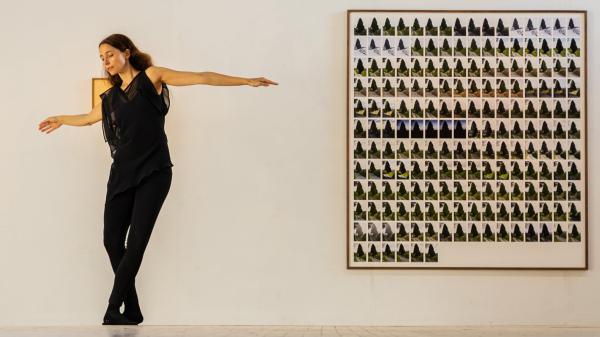 A woman dancing in front of a painting