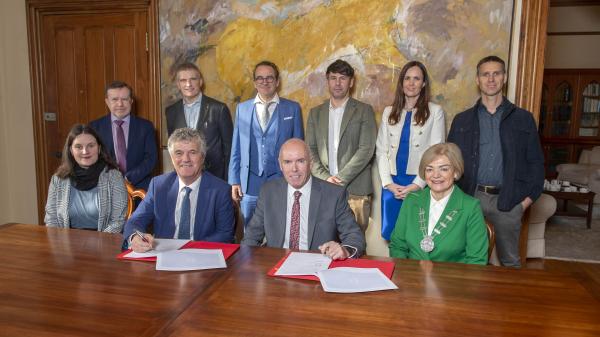 A group of people signing contracts at a table