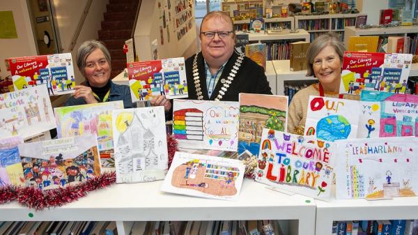 Pictured are Mayor Danny Collins with two staff members from Cork County Council's Library Service at Library HQ holding the 2023 Library Calendar