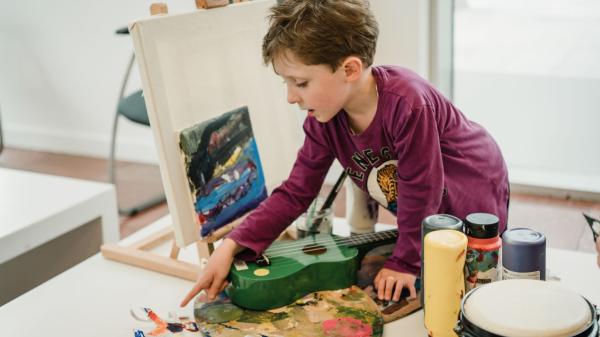 a child in school uniform playing with arts and crafts