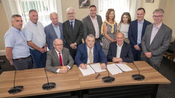 A group of men in suits signing a contract