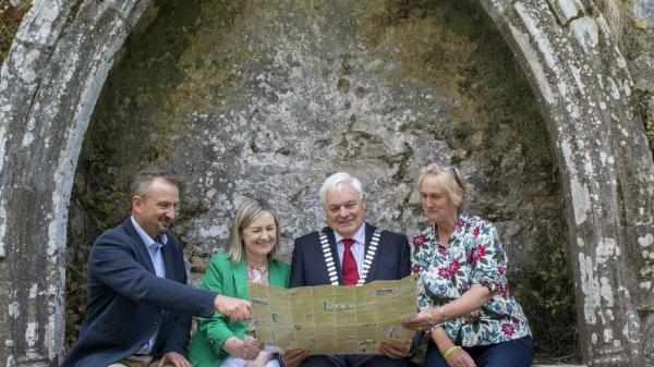 A group of people sitting with a map on a medieval structure