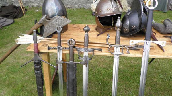 A picture of 5 swords leaning against a table