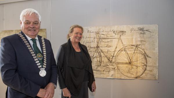 A man and a woman standing at a painting