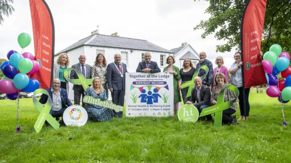 A group of people outdoors behind promotional material