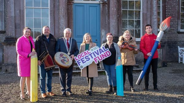 Seven people including the Mayor of the County of Cork, Cllr. Frank O'Flynn holding props and a sign at the launch of Cork County Council's Local Festival Fund.