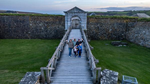 A group of people standing on a wooden bridge