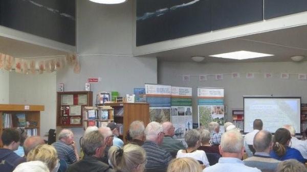 A group of people at a presentation in a library.