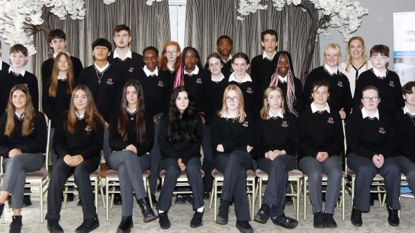 a group of children in school uniform sitting for a photo