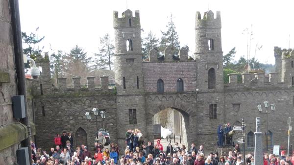 A castle with many people stadning outside