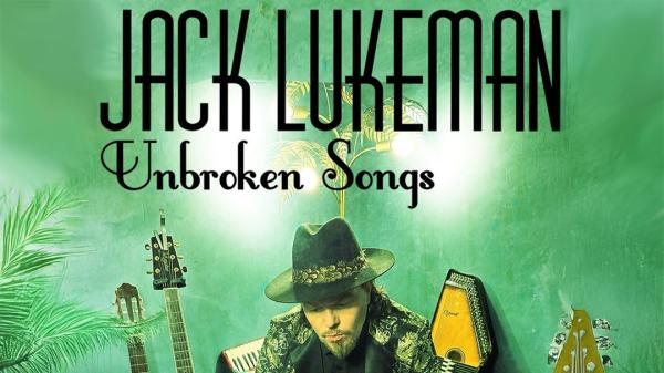A promotional poster for Jack Lukeman's "Unbroken Songs" with the artist seated among various musical instruments.