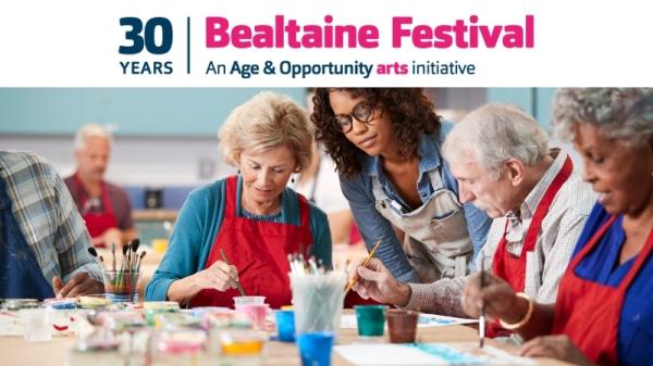 Attendees celebrating at Bealtaine Festival, surrounded by colourful banners and engaging in various cultural activities.