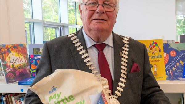 Mayor Joe Carroll holding bag inside library