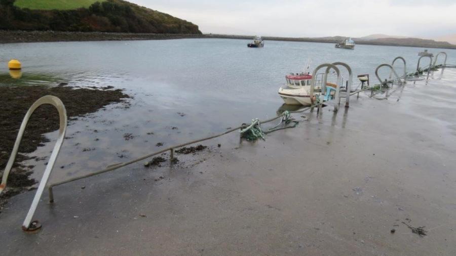 A boat is anchored on the shore by a Pier