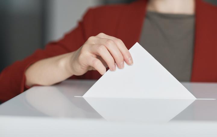 Person putting a ballot in to a ballot box