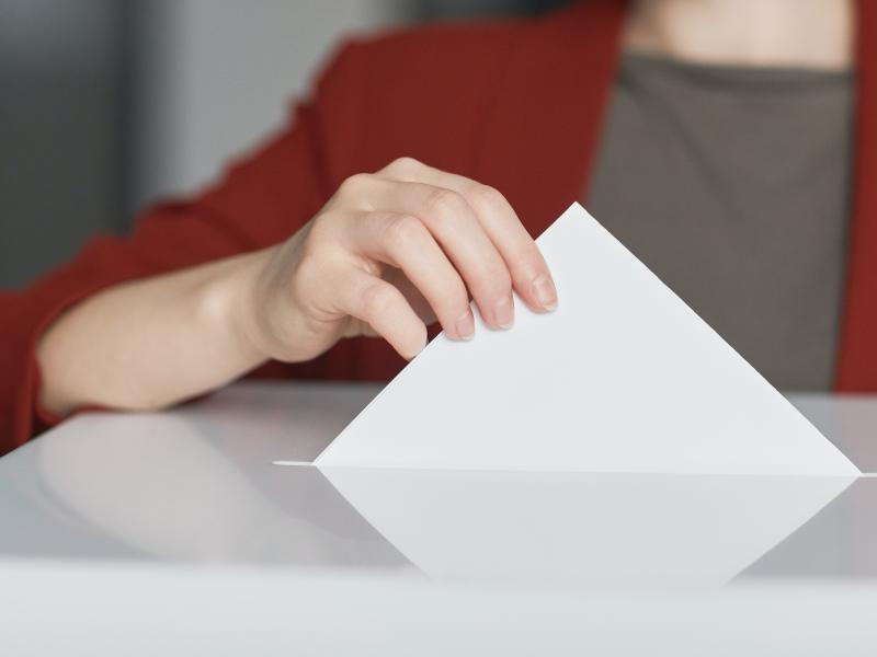 Person putting a ballot in to a ballot box