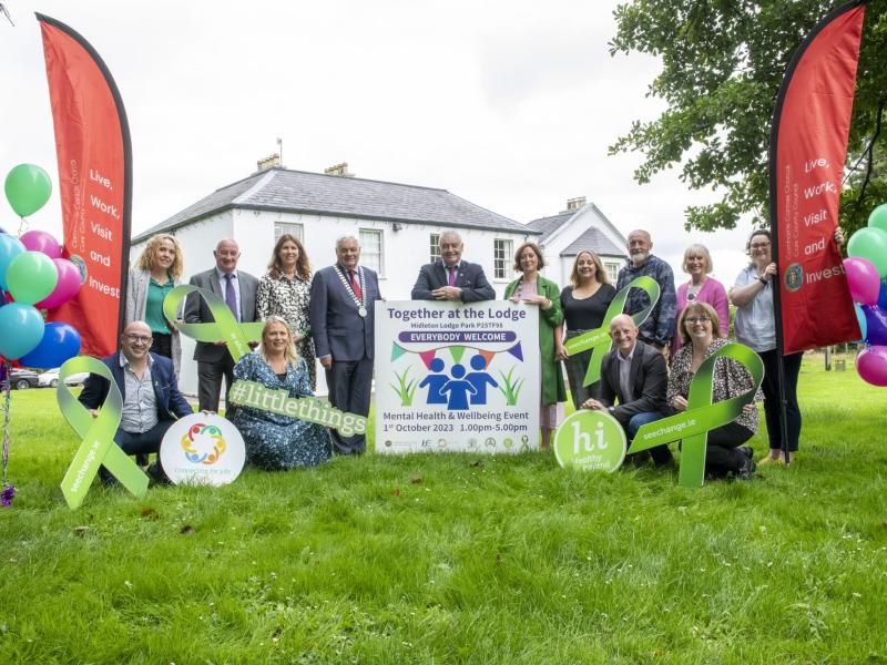 A group of people outdoors behind promotional material