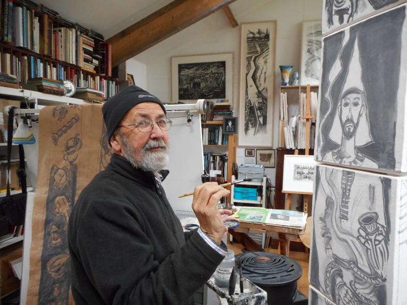 Brian Lalor holding a paintbrush in front of a canvas.