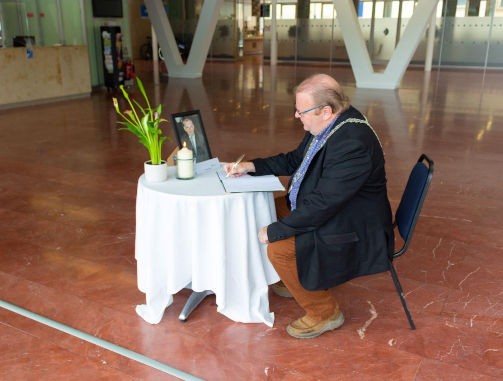 A person sitting at a table, signing a document