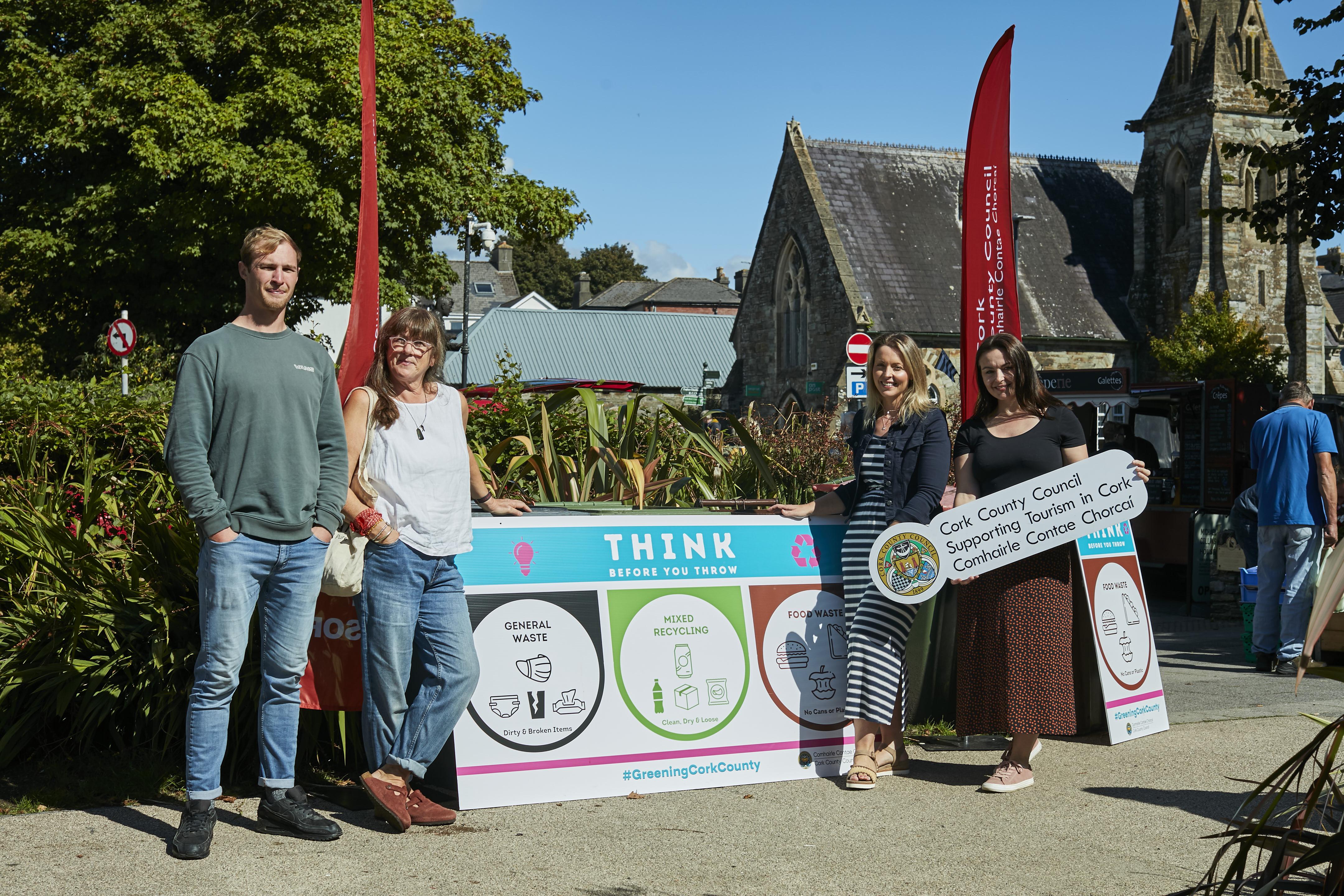 4 people standing in in front of a white sign promoting Cork County Council Green Festivals Pilot Programme