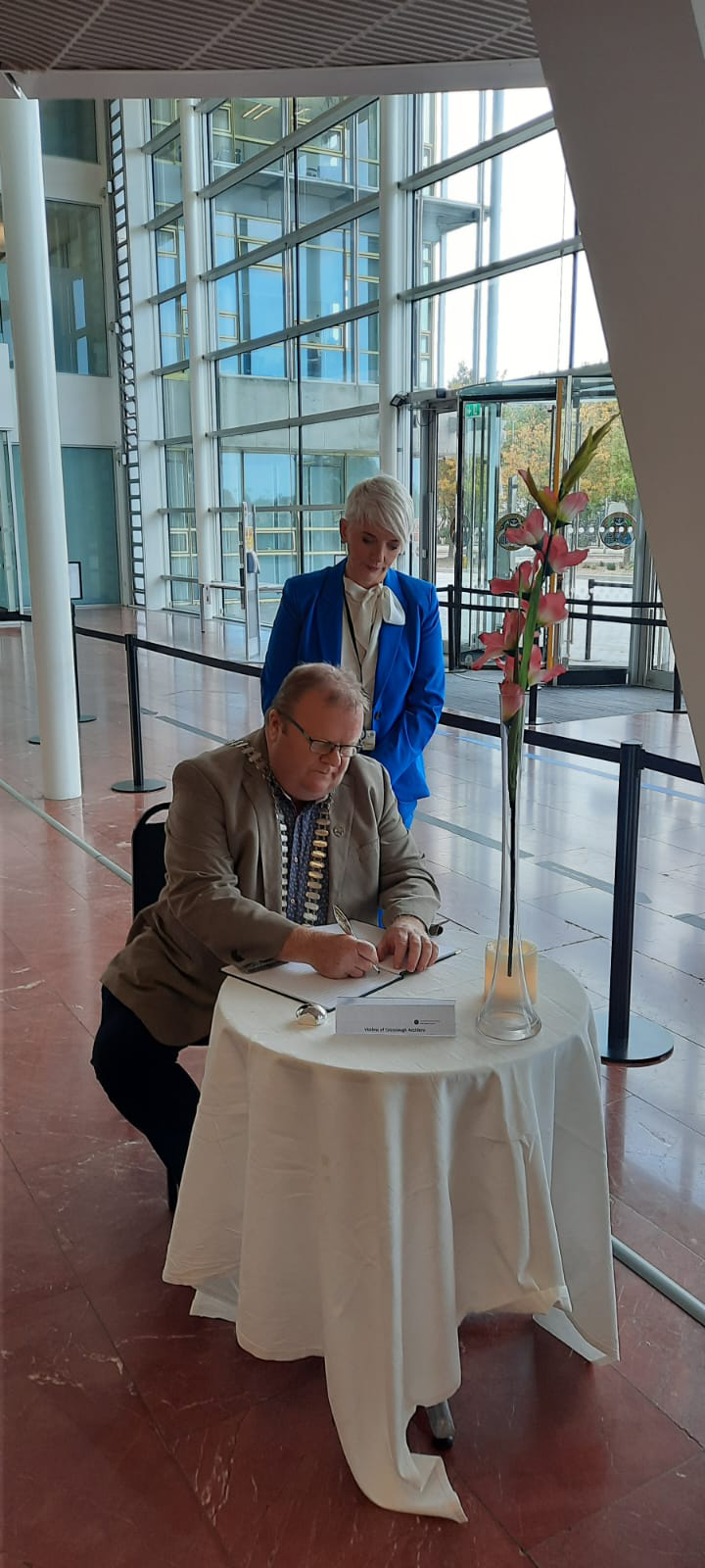 Two people signing a book