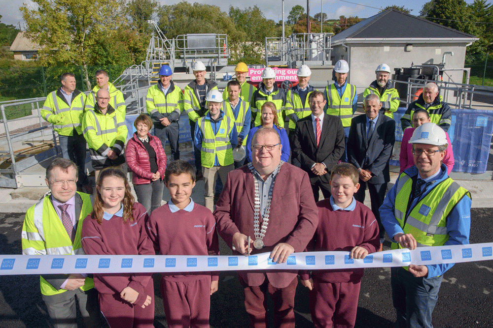 A group of people in safety vest cutting a ribbon