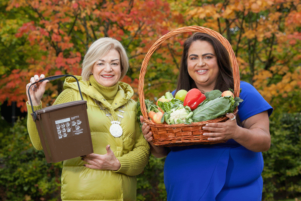 Two women holding props