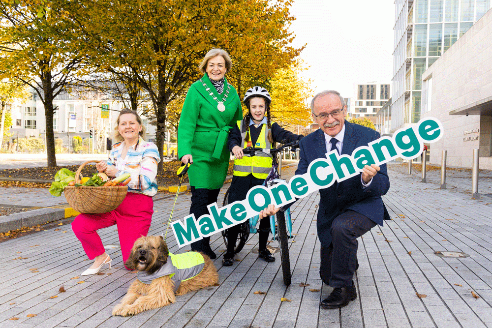 A group of people holding a sign saying make one change