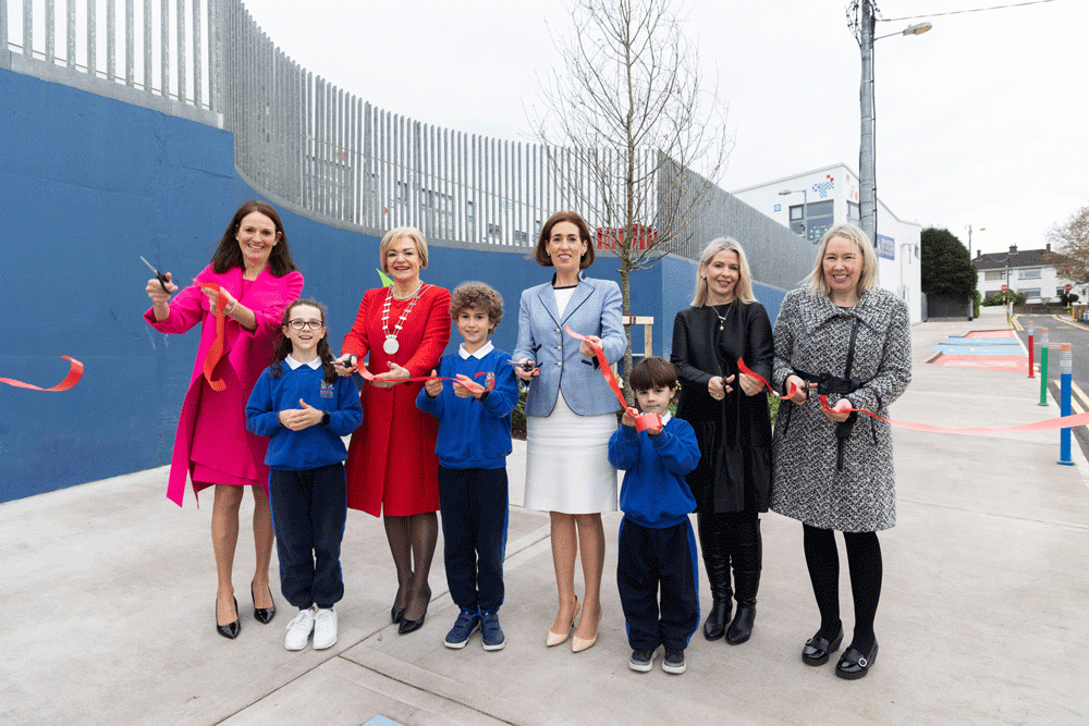 A group of woman and children cutting a ribbon