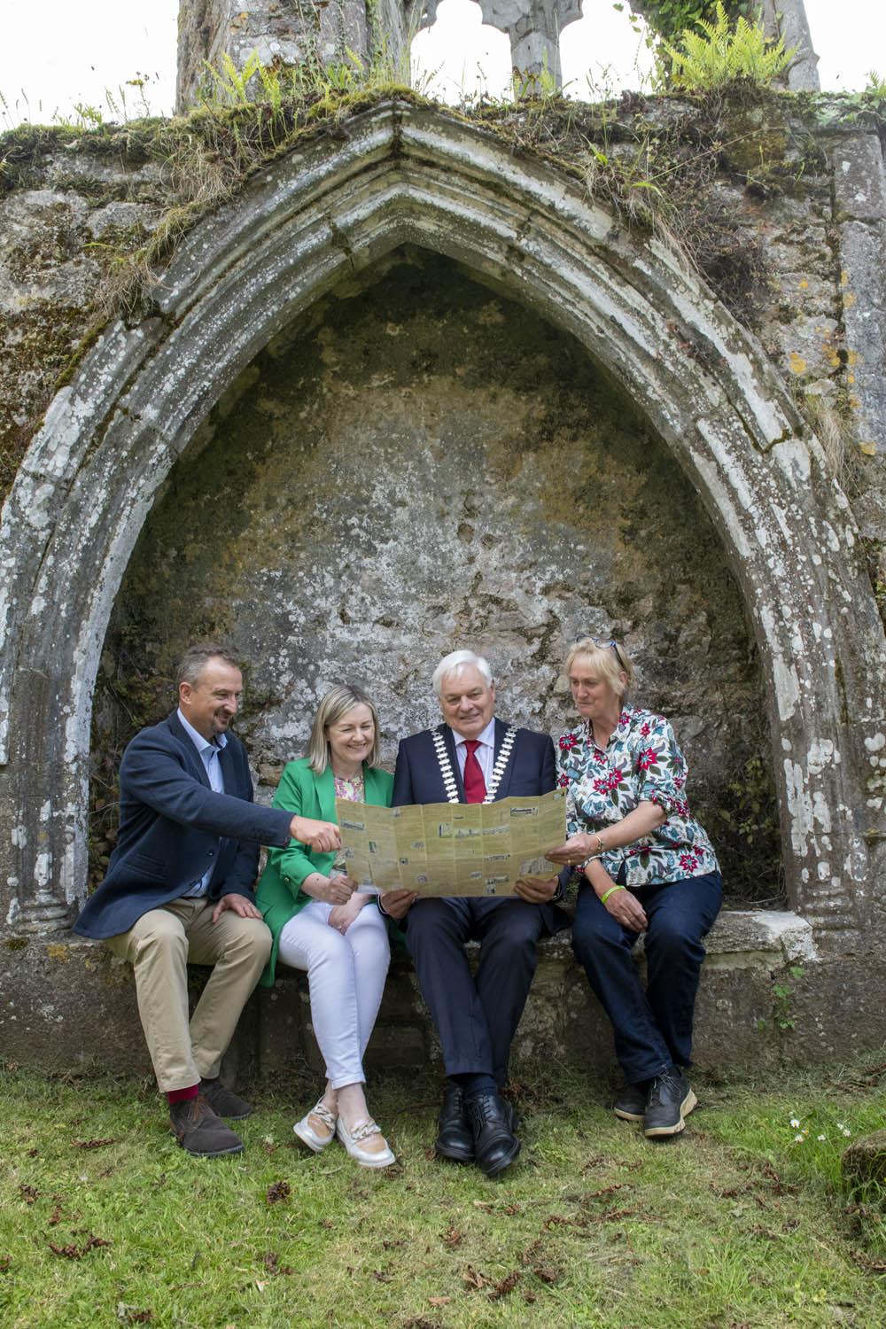 A group of people sitting with a map on a medieval structure