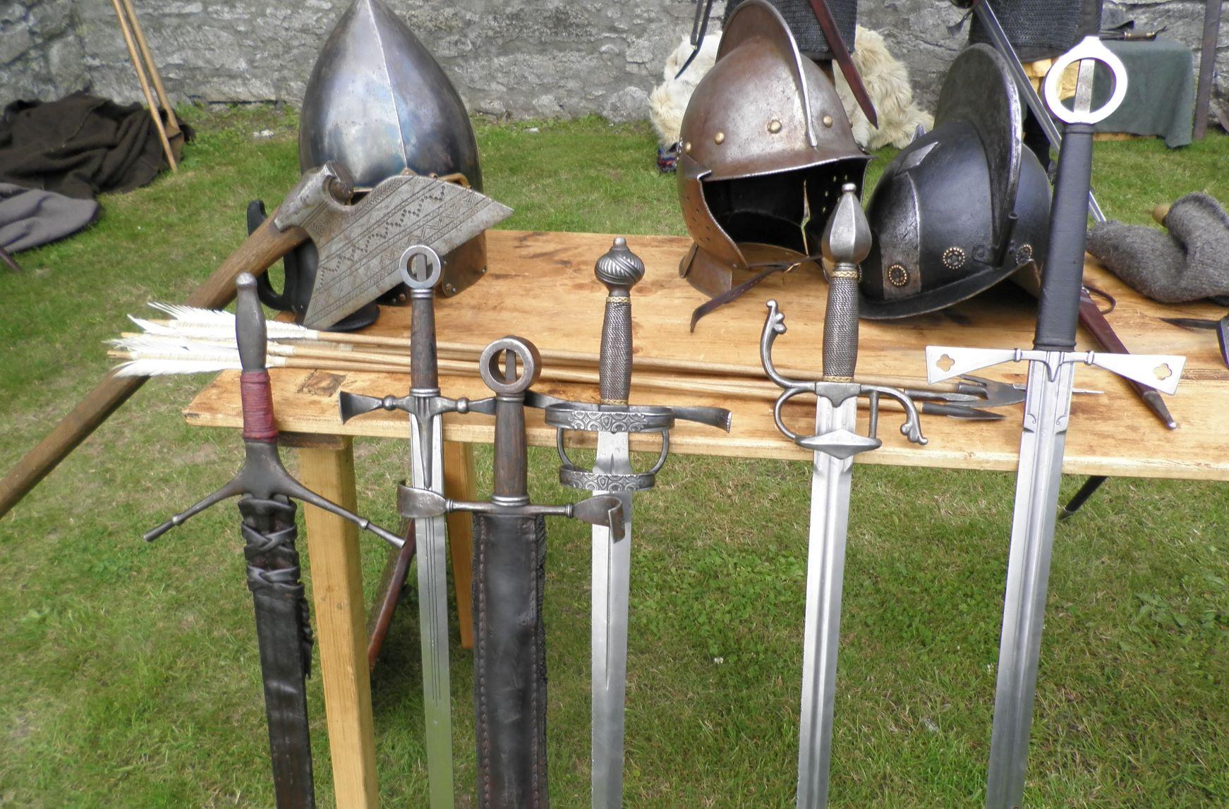 A picture of 5 swords leaning against a table