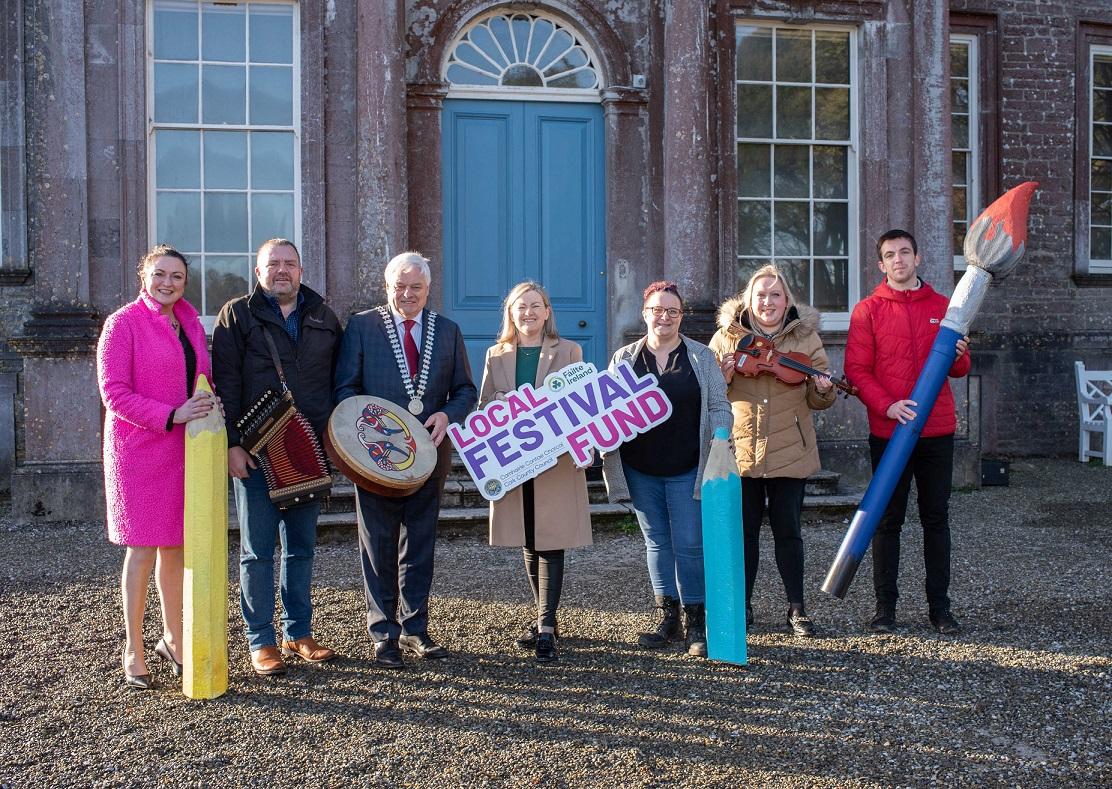 Seven people including the Mayor of the County of Cork, Cllr. Frank O'Flynn holding props and a sign at the launch of Cork County Council's Local Festival Fund.