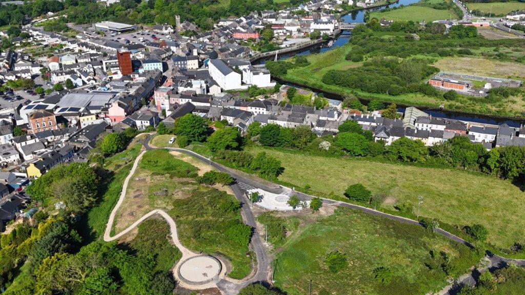 A brids eye view of a town with houses and green areas.