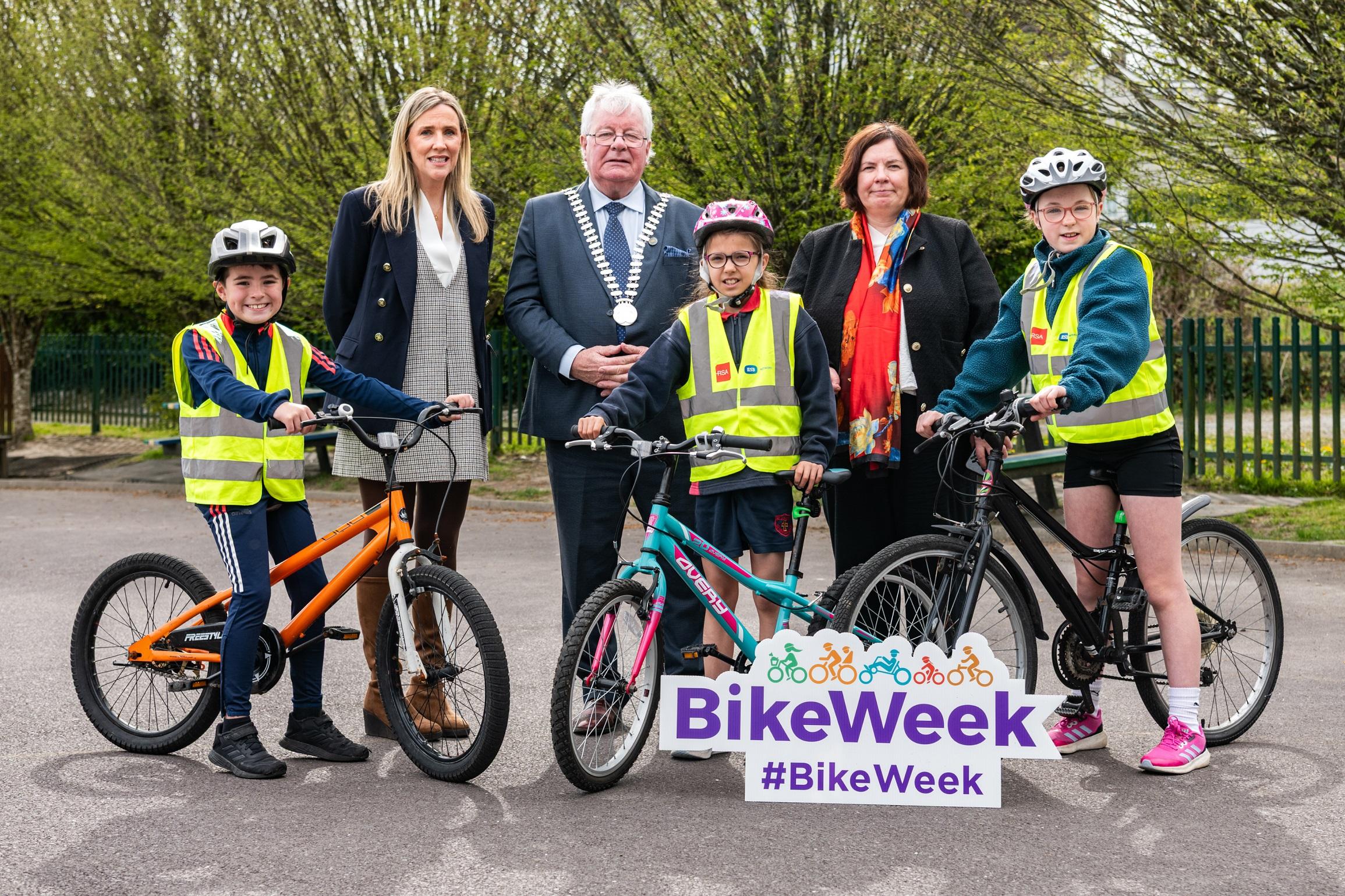 Mayor Joe Carroll and Chief Executive Moira Murrell with woman and 3 children on bikes advertising bike week.