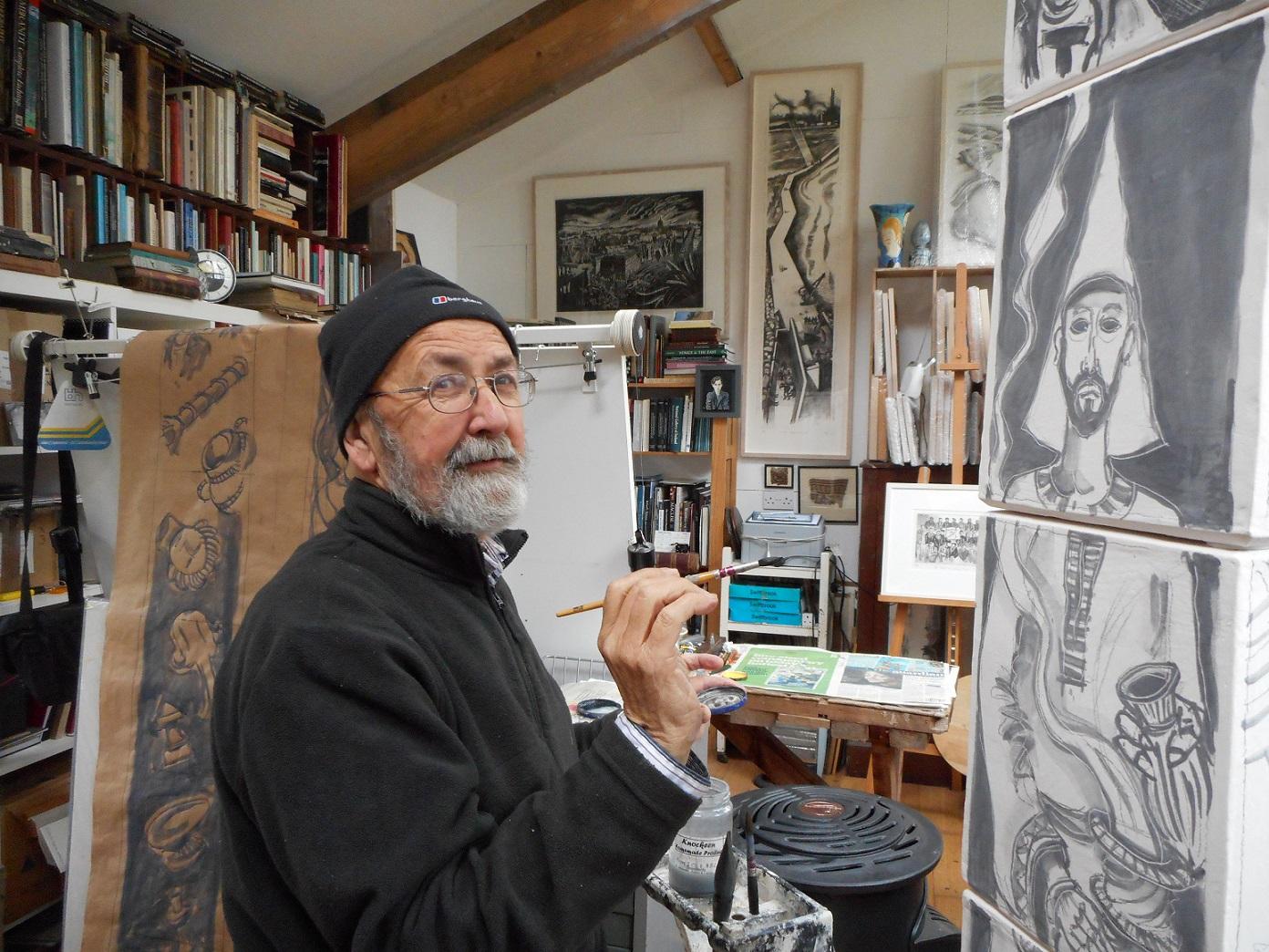 Brian Lalor holding a paintbrush in front of a canvas.
