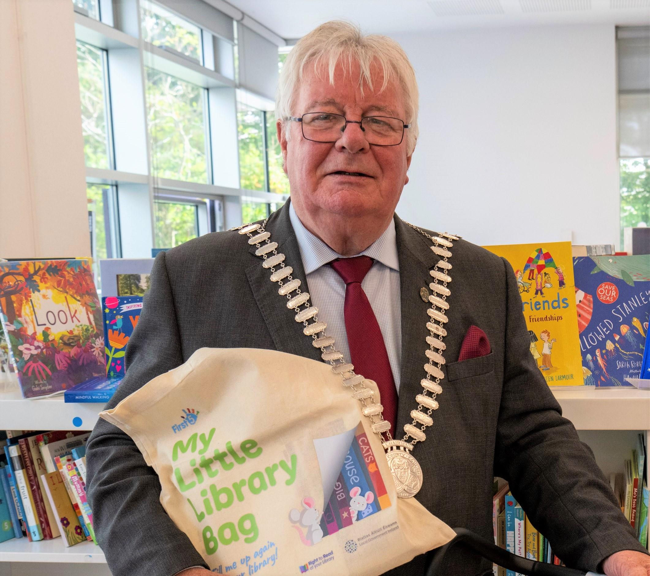 Mayor Joe Carroll holding bag inside library