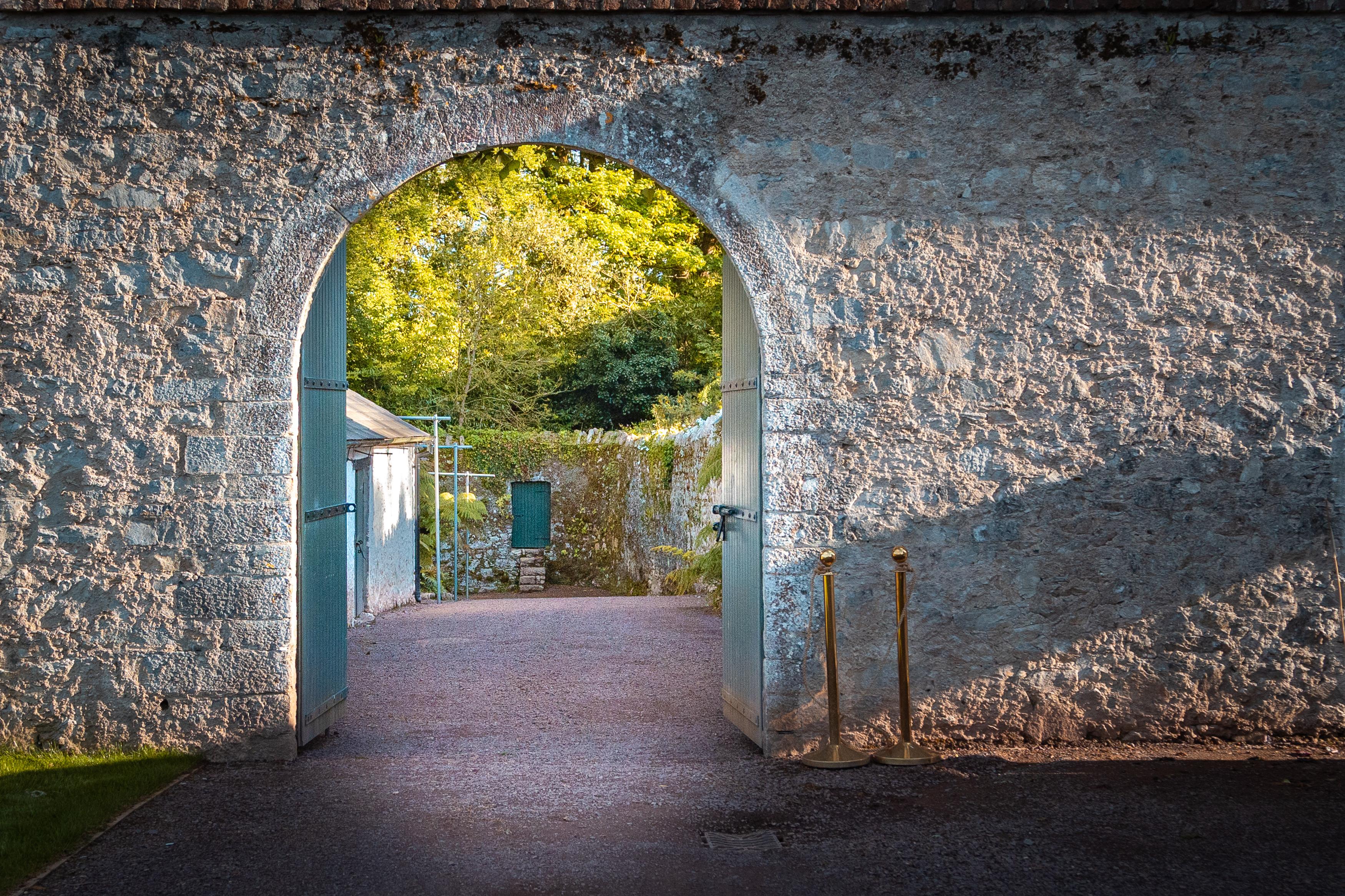 Stone wall with doorway into garden.